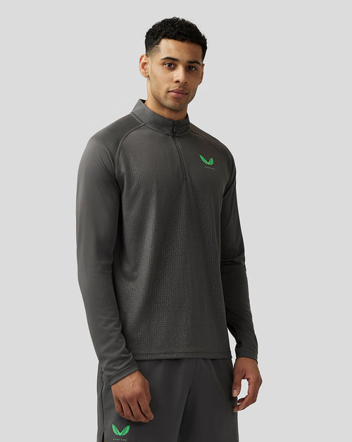 Male model wearing gunmetal Adapt quarter zip top with stand collar subtle geometric pattern and green Castore logo on chest
