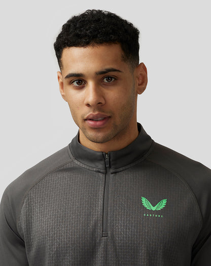 Close-up of a man wearing the gunmetal Adapt Print 1/4 Zip Top showing the quarter zip and green Castore left chest logo