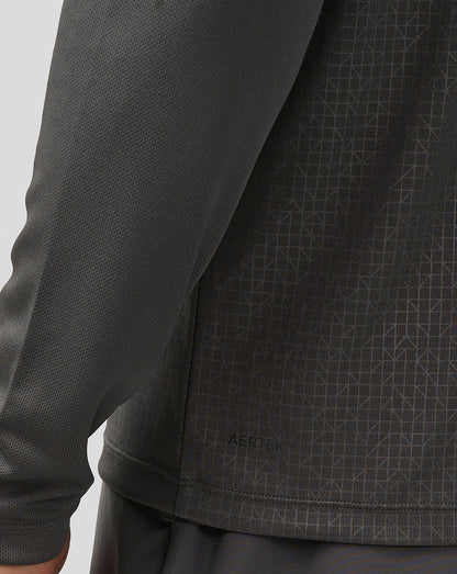 Close-up of back panel of dark gray long sleeve top with Aertek branding and geometric pattern detail