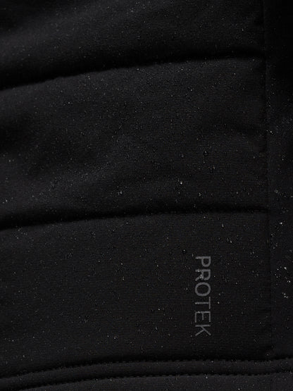 Close-up of black performance fabric with speckled texture and Protek branding on Apex Training Gilet