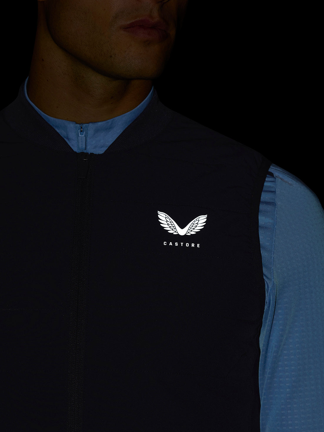 Close up of navy Apex Training Gilet showing front zipper and Castore logo on the chest