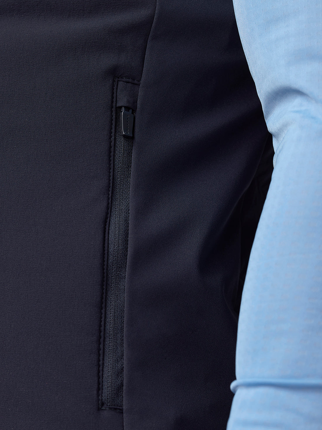 Close-up of side zip pocket on navy Apex Training Gilet with black zipper