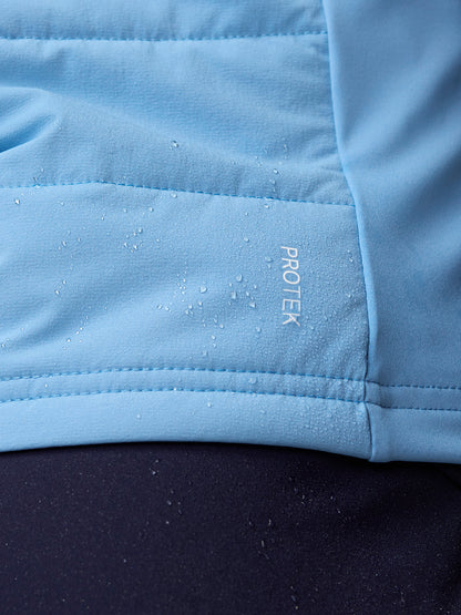 Close-up of sky blue Apex Training Gilet fabric with water droplets and ProTek branding.