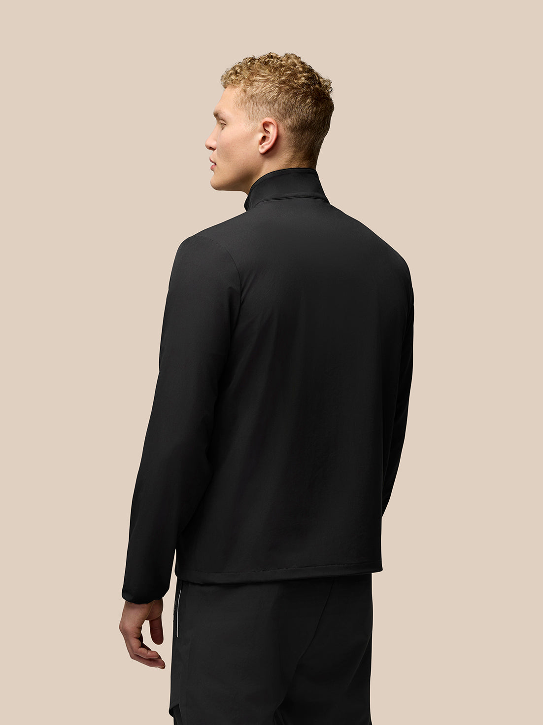 Rear view of the black Flex Cargo Jacket with stand collar on a model