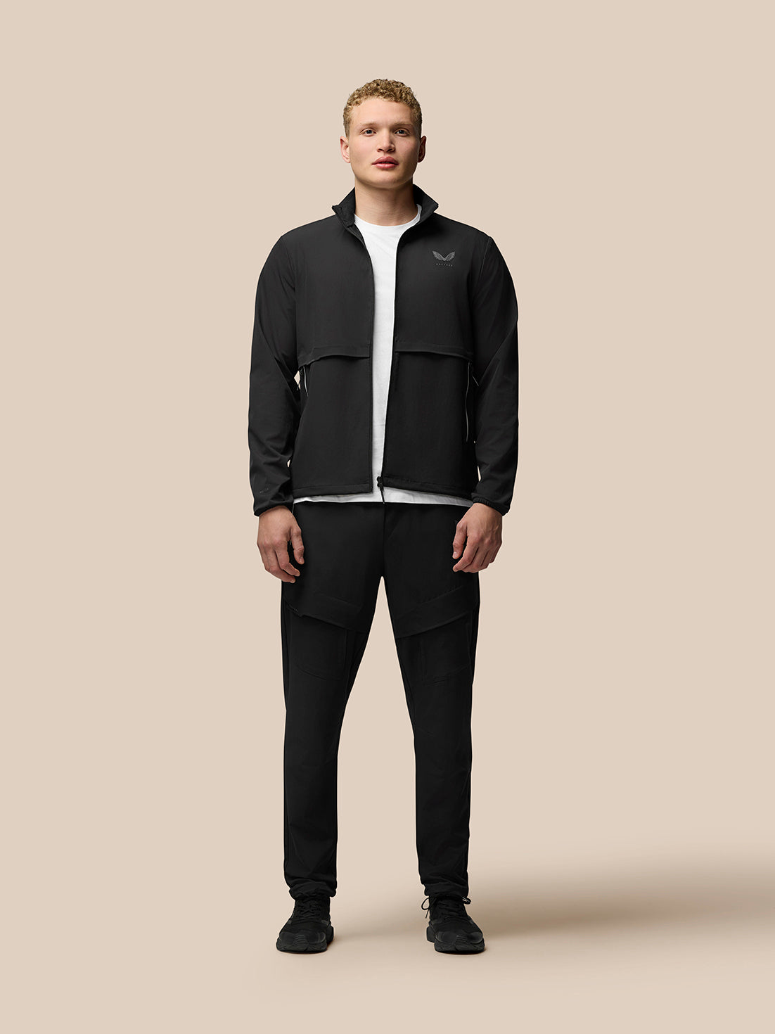 Full-body view of a man wearing the black Flex Cargo Jacket with zip front and stand collar