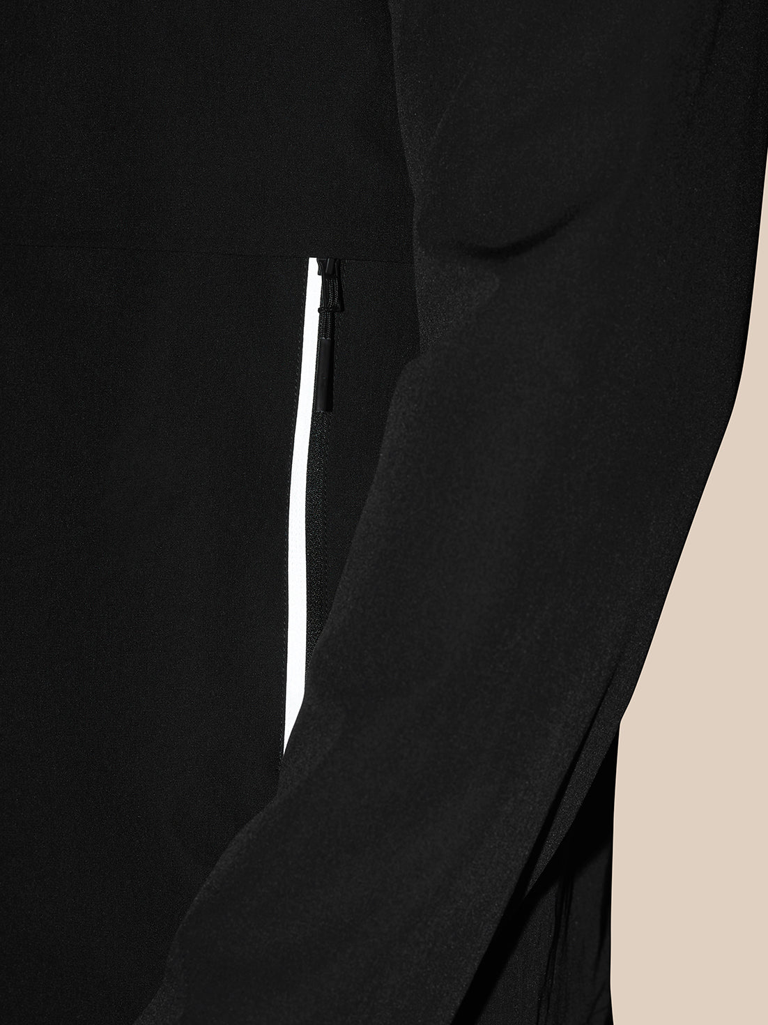 Close-up of black Flex Cargo Jacket side pocket with vertical zip and white trim