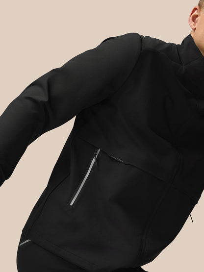 Side view of black Flex Cargo Jacket showing a zippered pocket and Castore branding on the chest