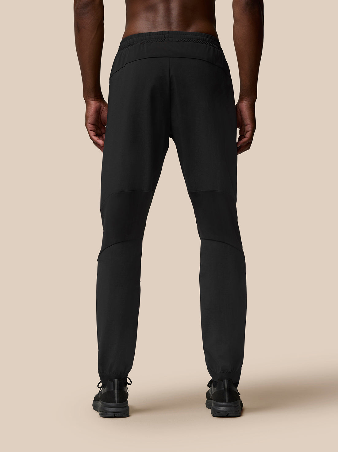 Back view of black Flow Training Joggers with panelled silhouette and tapered cuffs.