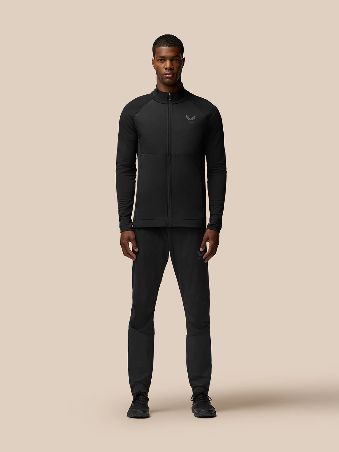 Male model wearing Flow Training Joggers in black with panelled design and Castore branding on thigh and calf