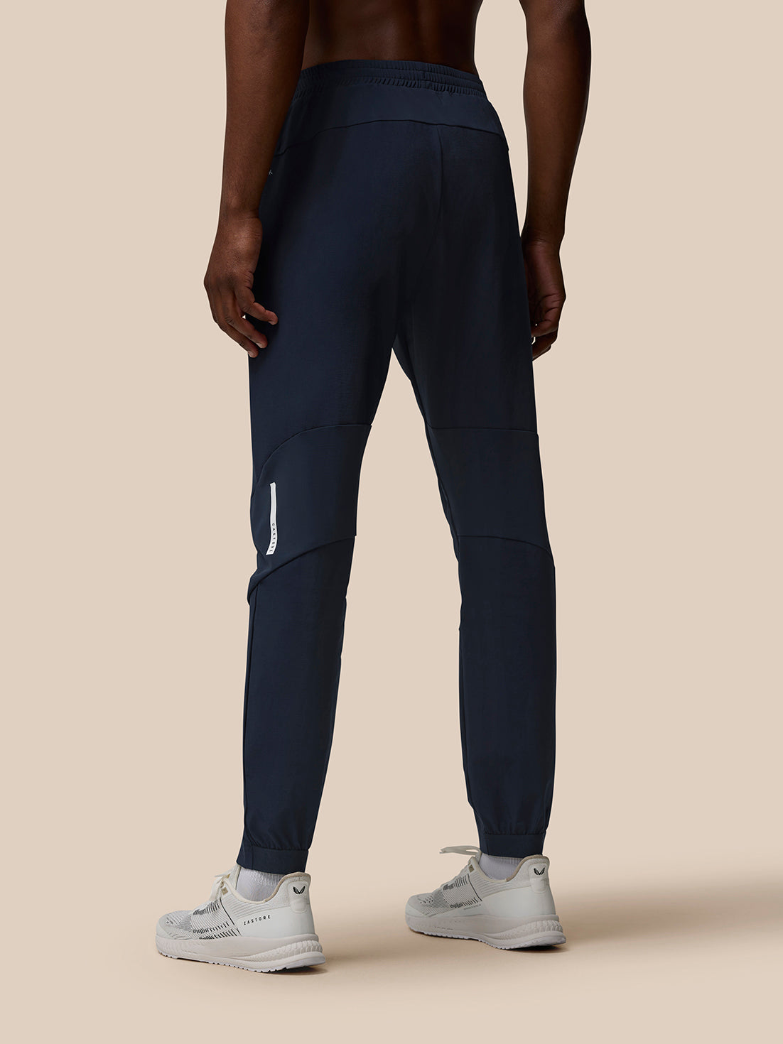 Back view of male model in navy Flow Training Joggers highlighting panelled design and elastic waistband