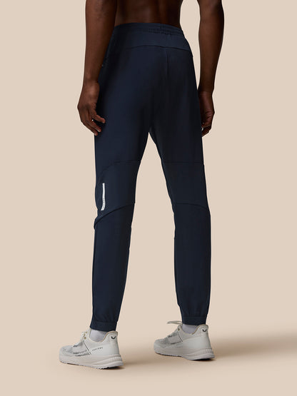 Back view of male model in navy Flow Training Joggers highlighting panelled design and elastic waistband
