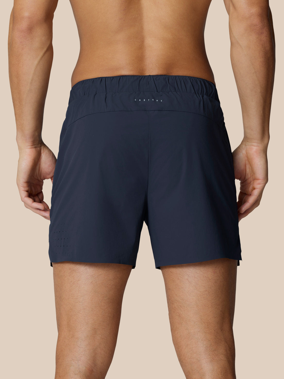 Rear view of navy Zone Training Shorts on a male model with reflective branding at center rear.