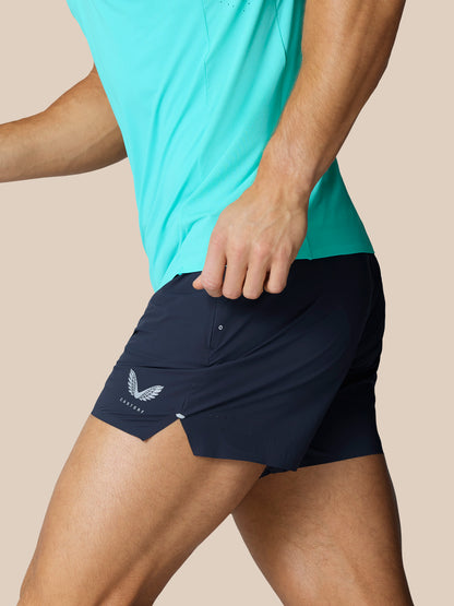 Side view of navy Zone Training Shorts on a model with the Castore wing logo visible on the left thigh