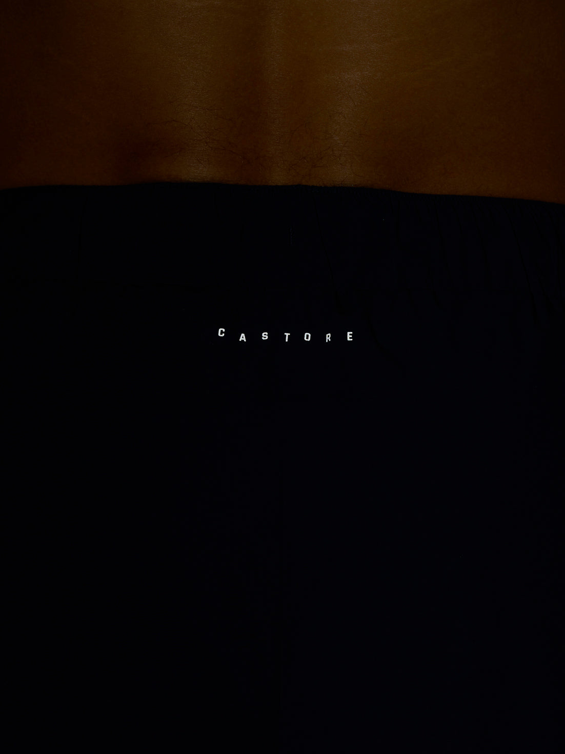 Close-up of navy shorts waistband showing white CASTORE branding.