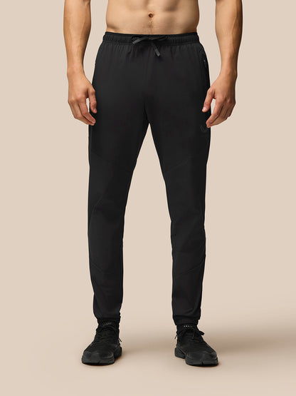 Front view of male model in black Flex lightweight joggers with a drawstring waist and tapered cuffs