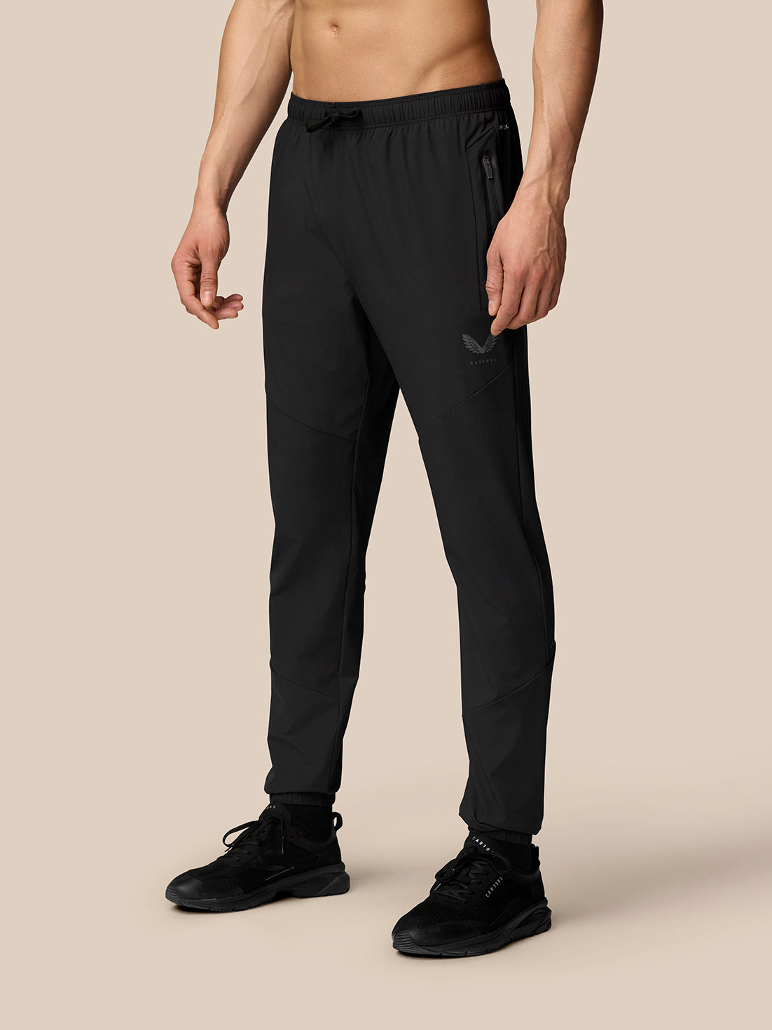 Flex Classic Lifestyle Joggers in black on a model; tapered pants with drawstring waist zipped pockets and Castore logo on left thigh.