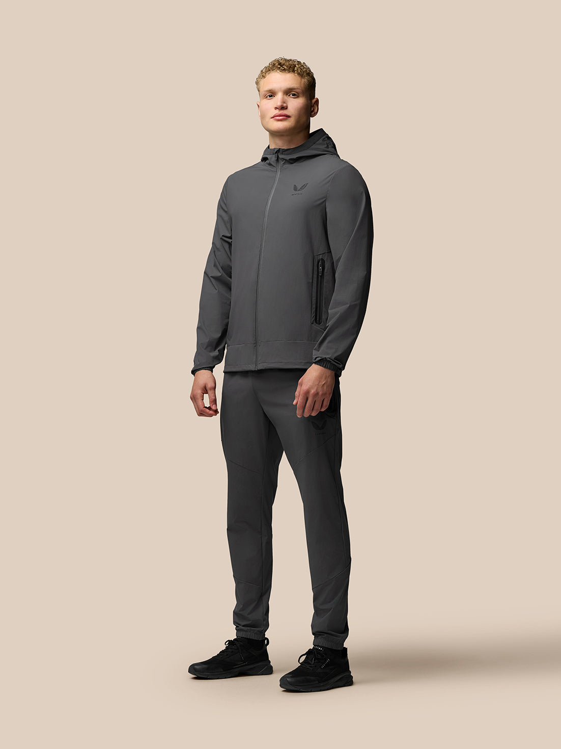 Male model wearing a grey Flex Classic Set Woven jacket and matching joggers.