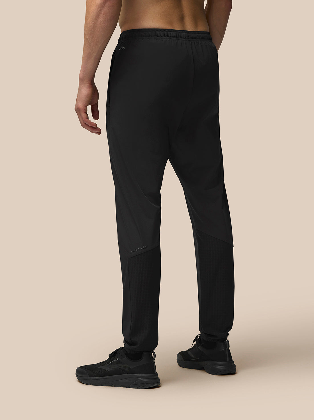 Back view of black Winterised Flex Joggers showing Castore branding on the left thigh and Protek on the left rear.