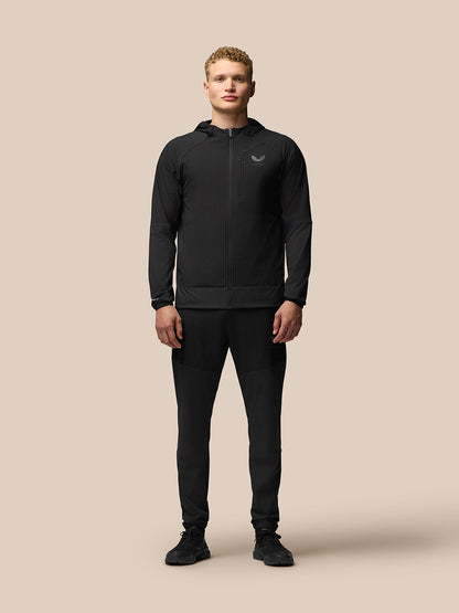 Male model wearing black Winterised Flex Joggers with elastic cuffs and a matching jacket