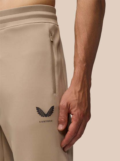 Beige jogger side view featuring a vertical zip pocket and Castore logo near the calf