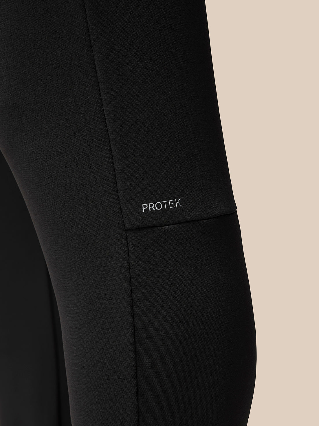 Close-up view of black Flex Thermo Joggers fabric with PROTEK branding on the left thigh.