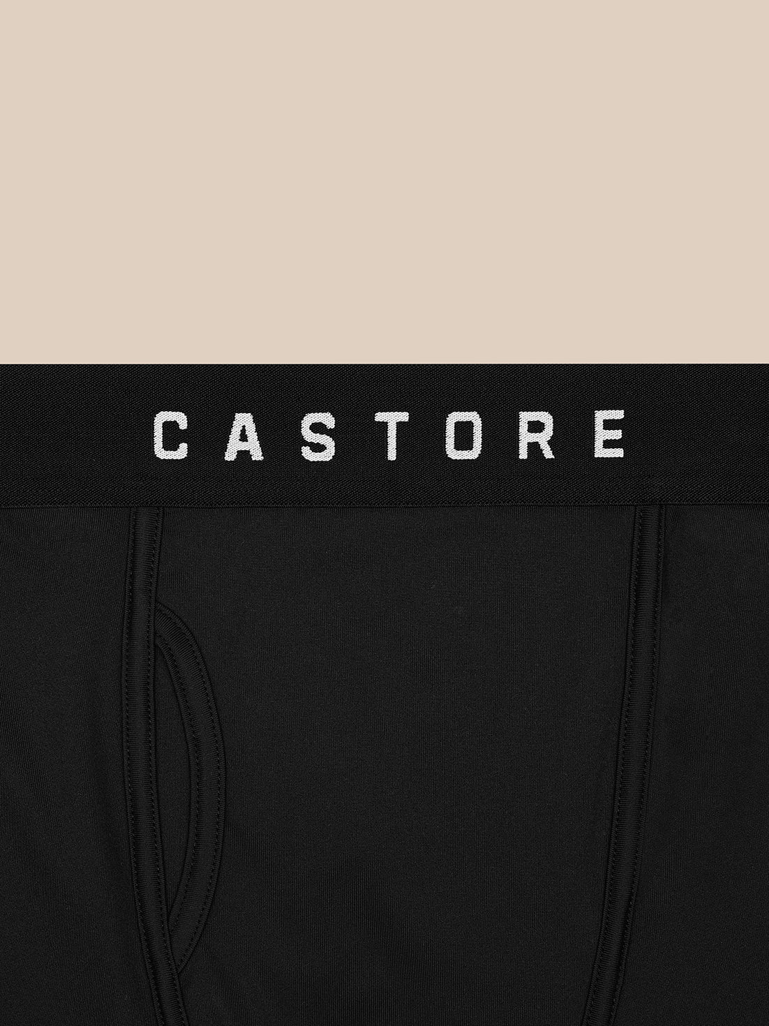 Close-up of black Castore boxer waistband with white CASTORE logo on a beige background