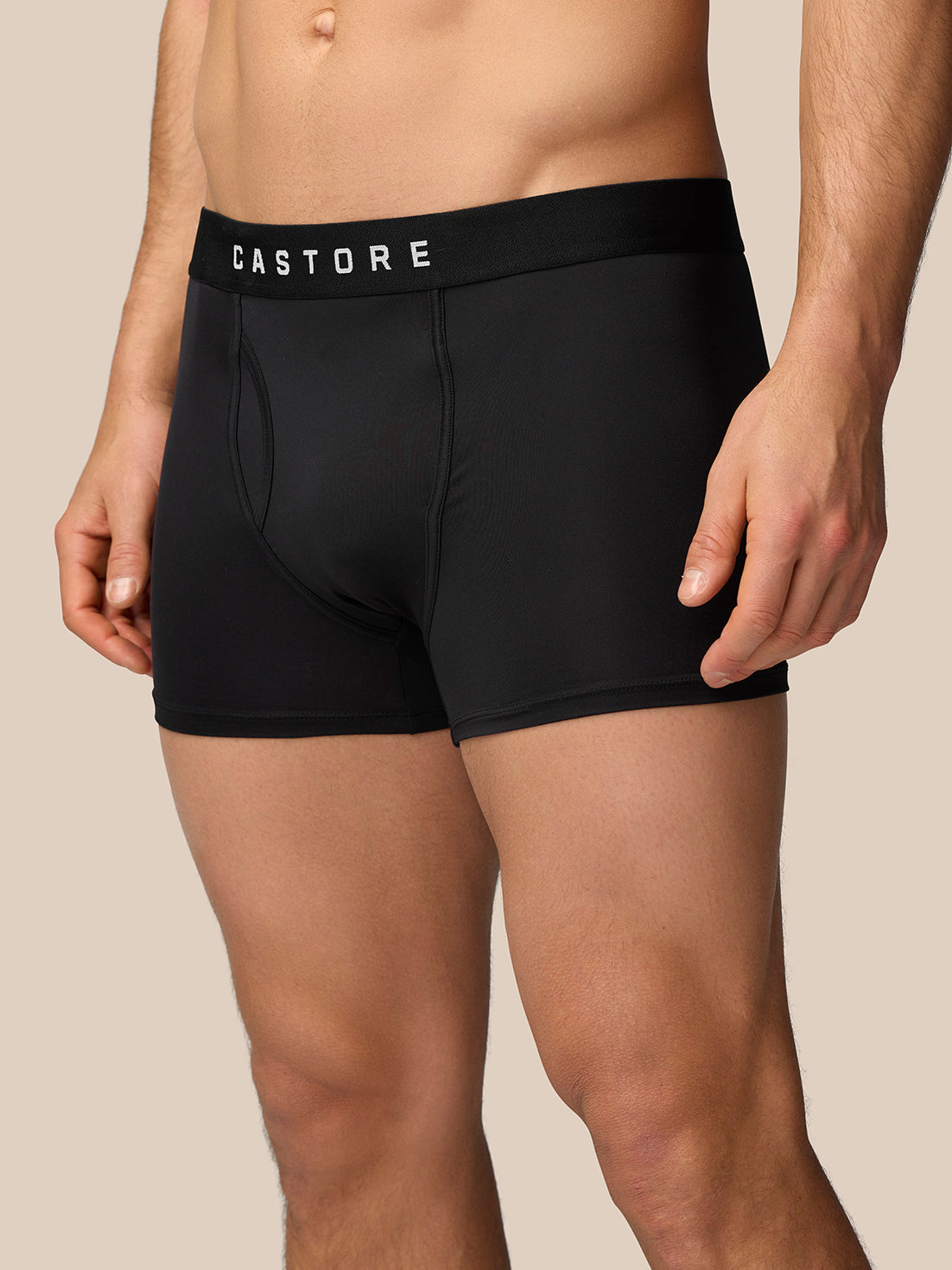 Male model wearing black Castore boxer shorts with a wide elastic waistband, close-up of hips and thighs
