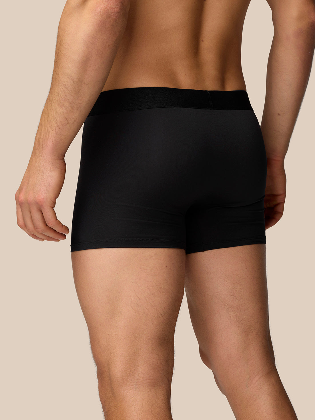 Back view of male model wearing black Castore boxer shorts, showing snug fit and elastic waistband