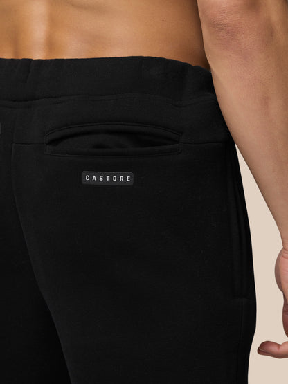 Back view of black Adapt Fleece Joggers showing a welt pocket and Castore badge