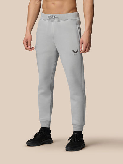 Grey Adapt Fleece joggers on a model with logo on the thigh and cuffed ankles paired with black sneakers