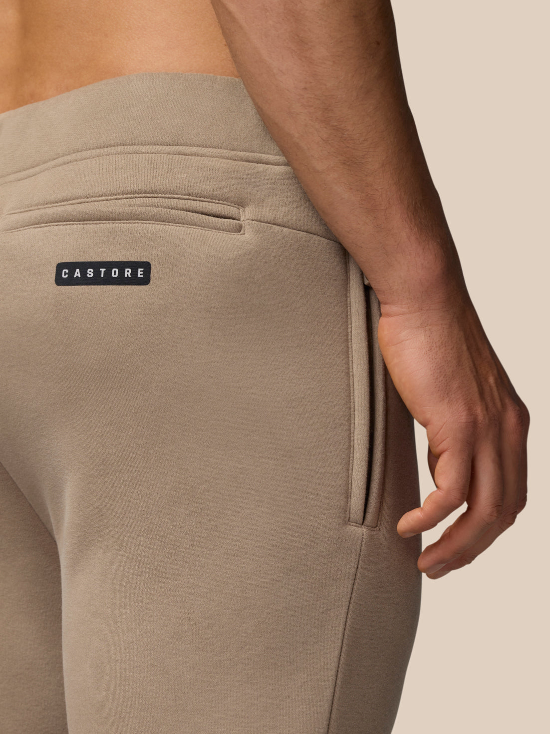 Beige Adapt Fleece joggers back pocket detail with Castore label