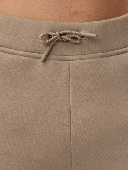 Back waist close up with a tied beige drawcord and Castore branding on the drawcord tips.