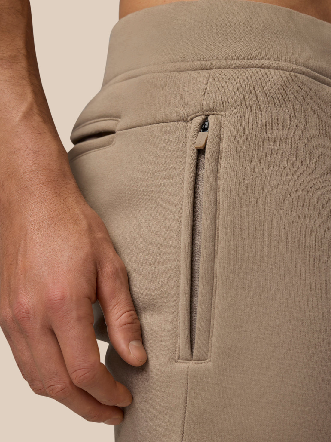 Close up of Adapt Fleece Joggers in Clay showing a vertical hip zip pocket.