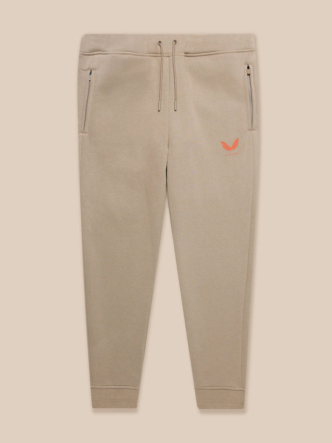 Beige Adapt Fleece joggers full view with zip pockets and small orange logo on the thigh