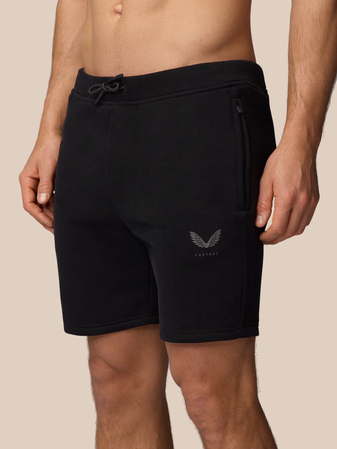 Close up of a man wearing black Adapt Fleece Jogger Shorts showing drawcord waistband and zip pocket