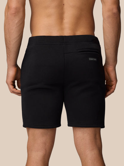 Back view of black Adapt Fleece Jogger Shorts with a rear pocket and small Castore logo