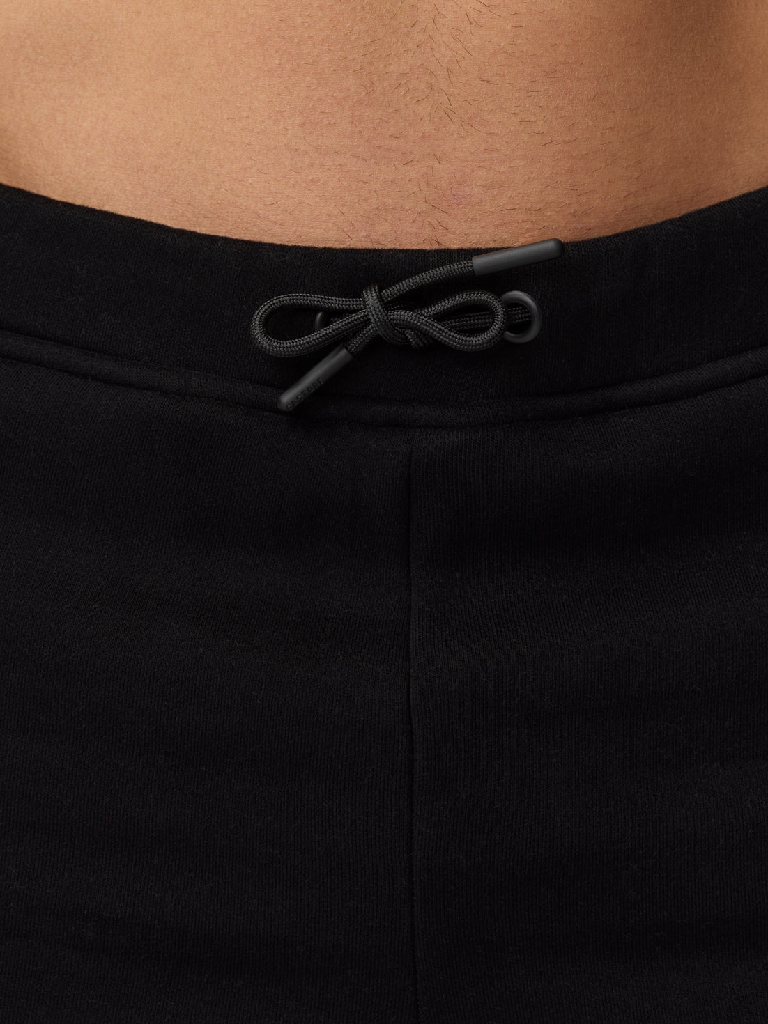 Close up of waistband with a drawcord on black Adapt Fleece Jogger Shorts
