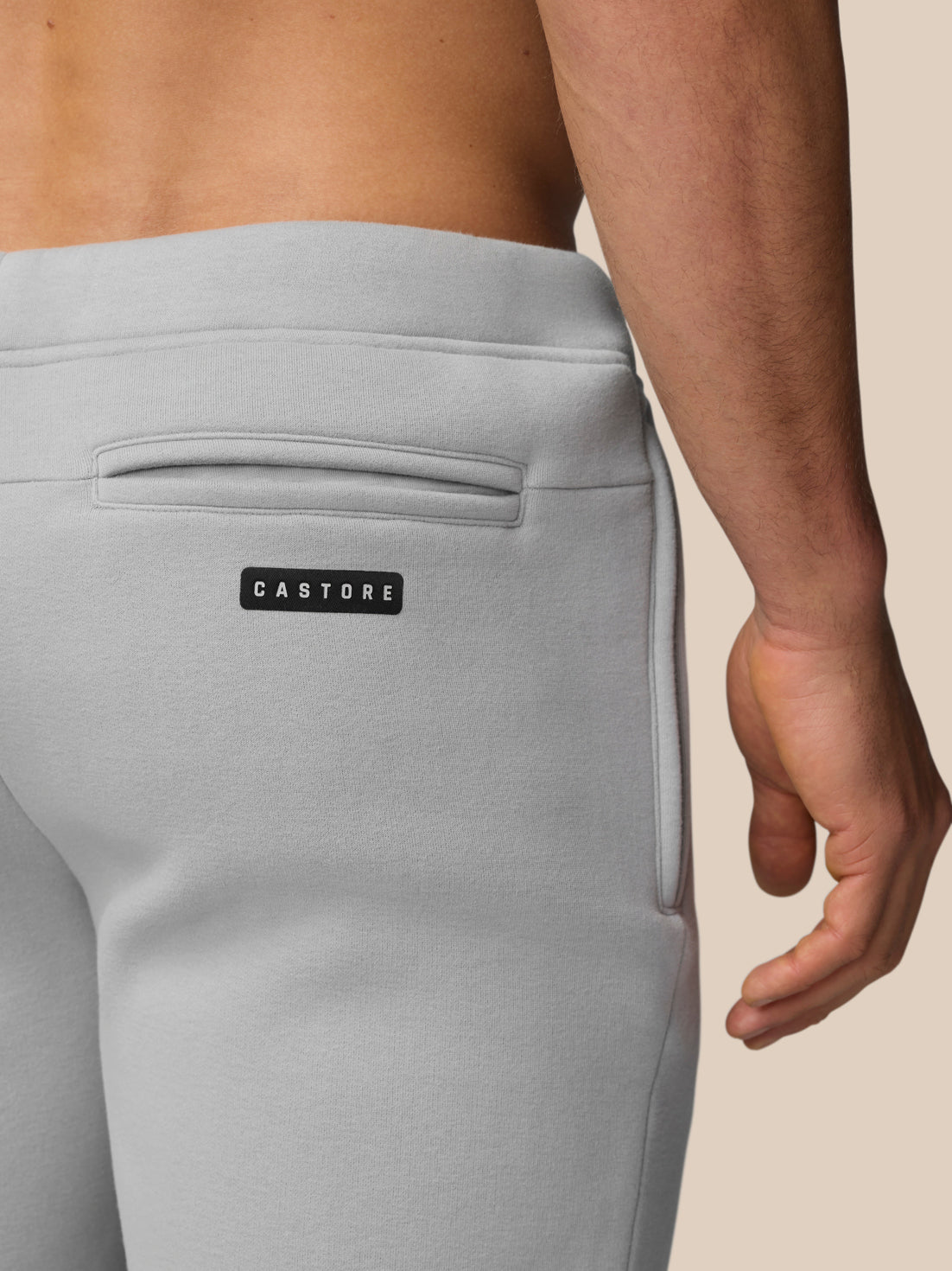 Close-up of back of grey Adapt Fleece Jogger Shorts showing a back zip pocket and Castore logo.