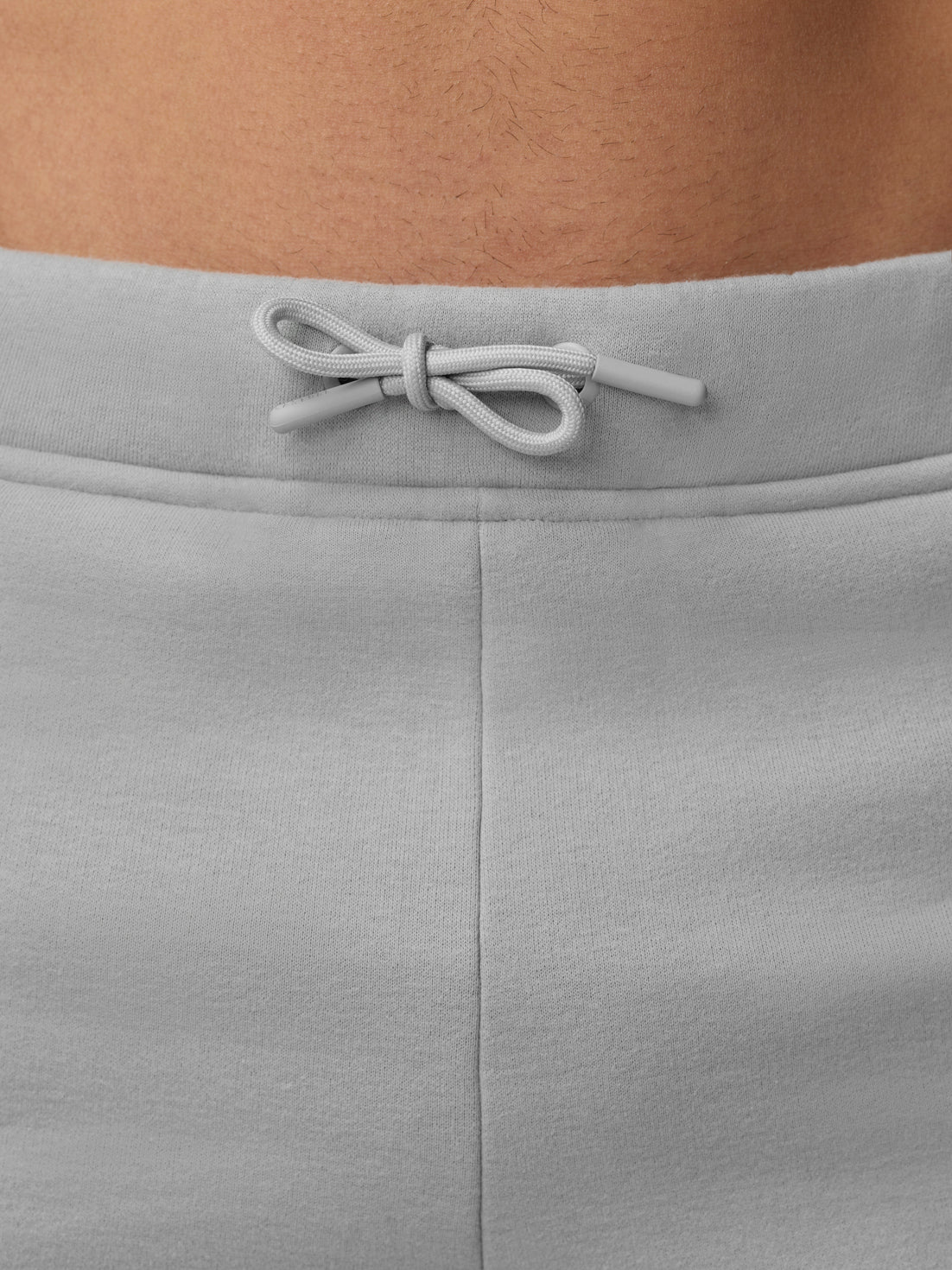 Close-up of grey waistband with drawstring tied in a bow on Adapt Fleece Jogger Shorts.
