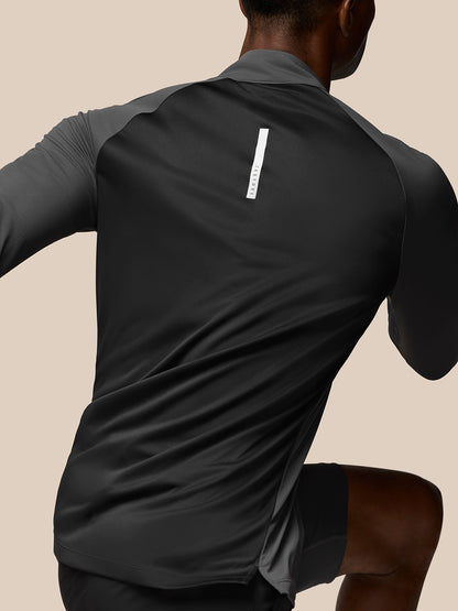Back view of a man wearing a gunmetal Flow Training top with a vertical Castore label on the back