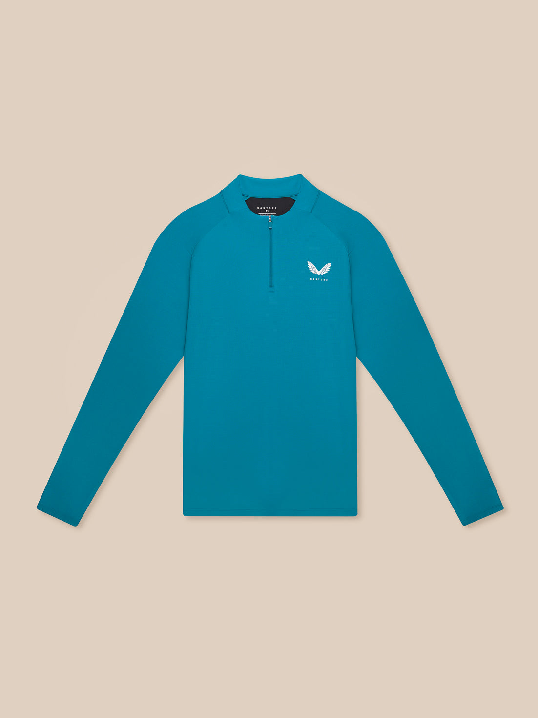 Flat lay of teal Flow Training top with quarter zip on beige background