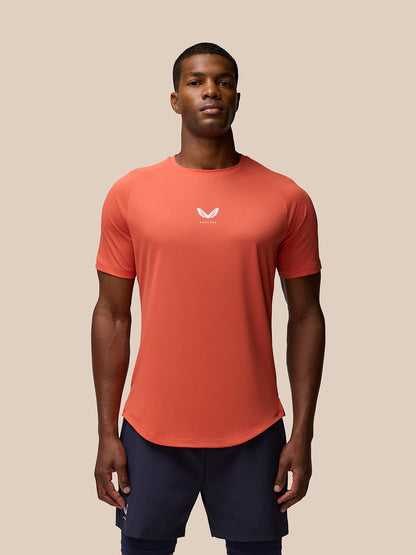 Male model wearing bright orange breathable gym T-shirt with centered white logo.