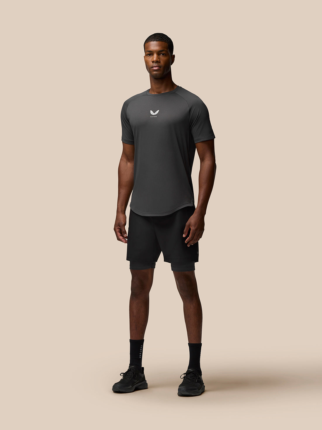 Front view of a man in a charcoal Flow Training T-Shirt featuring a small Castore logo on the chest