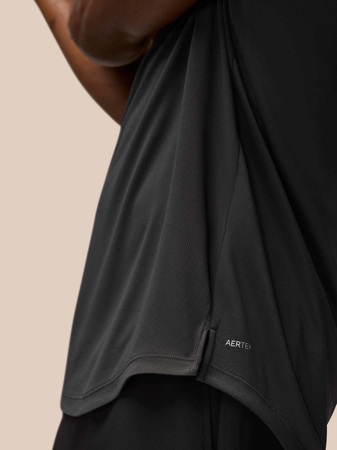 Close-up of Flow Training T-Shirt in charcoal showing mesh back panel and AerTek branding on fabric