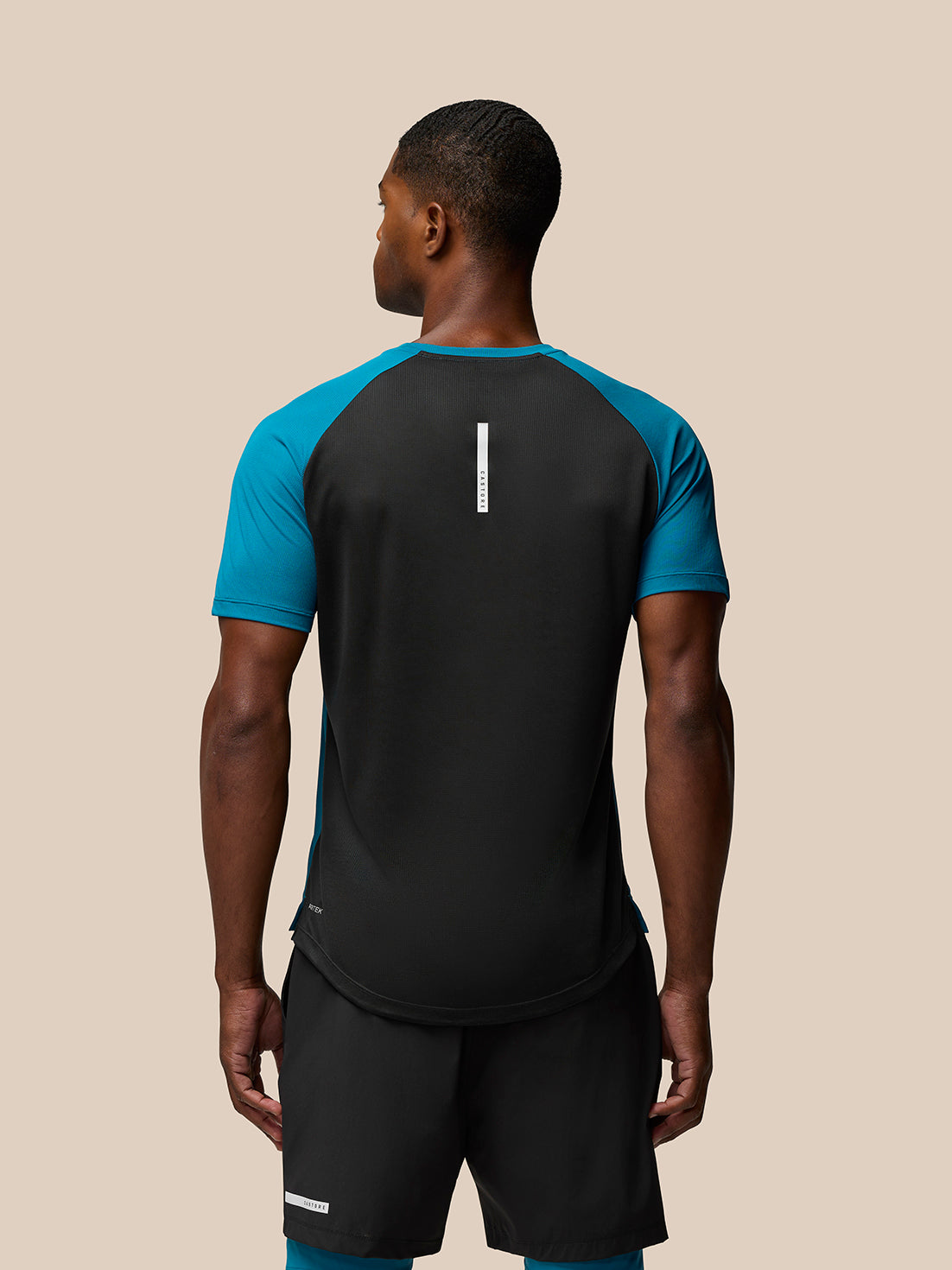 Back view of Flow Training T-Shirt Dark Aqua on a male model showing center back branding