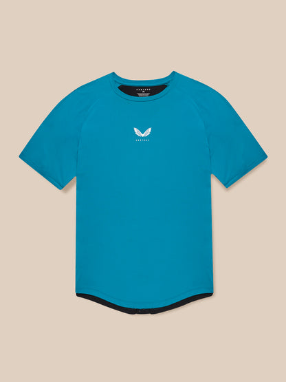Male model wearing Flow Training T-Shirt in dark aqua with center chest logo front view against beige backdrop