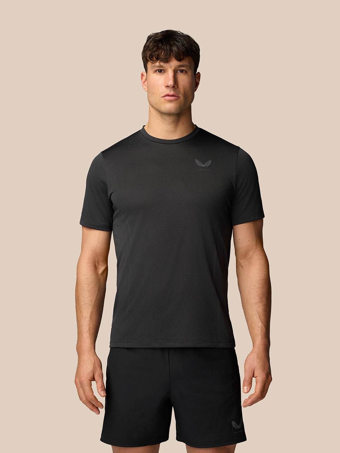 Front view of a man wearing black Apex Training T-Shirt with crew neck and reflective branding on chest