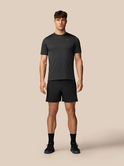 Male model wearing black Apex training T-shirt and matching shorts, standing facing the camera.