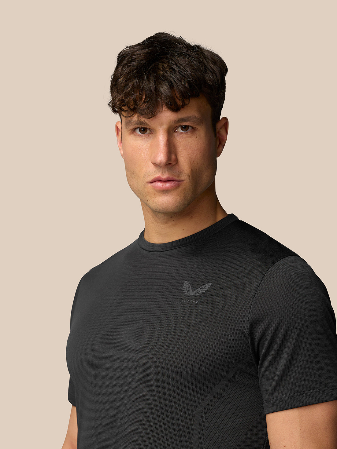 Front view of a male model wearing a black Apex Training T-Shirt with crew neck and reflective branding on the chest.