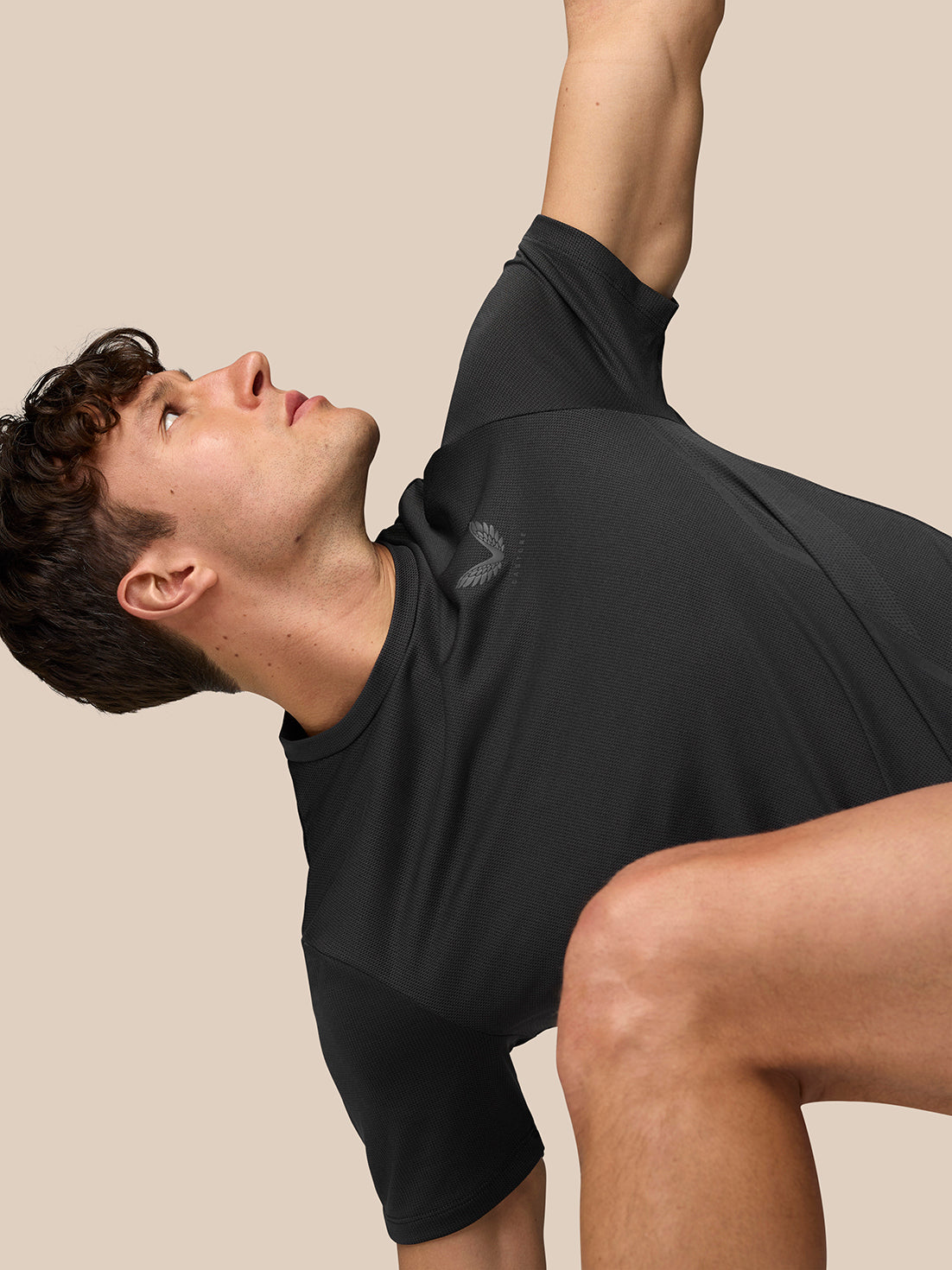 Male model wearing black Apex training T-shirt with short sleeves and breathable knit fabric.